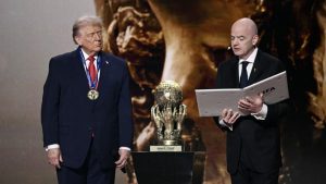 (Kiri/Kanan) Presiden AS, Donald Trump, memperhatikan saat menerima Hadiah Perdamaian FIFA (FIFA Peace Award) dari Presiden FIFA, Gianni Infantino, selama pengundian Piala Dunia 2026 yang berlangsung di AS, Kanada, dan Meksiko, di Kennedy Center, Washington, DC, pada 5 Desember 2025. 